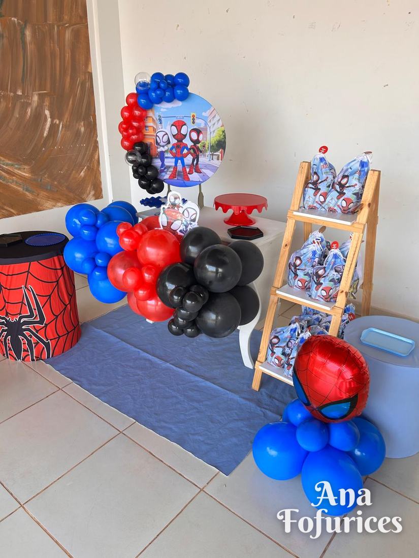 Festa do Spidey com balões azuis, vermelhos e pretos, cilindro de teia e escadinha com lembrancinhas